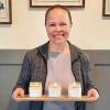 Heidi Bordenave of Farmstead Candle Company smiling and holding a tray of her family's handpoured candles