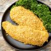 Breaded chicken breasts on black plate