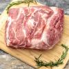 Pork Shoulder roast on cutting board with rosemary garnish