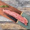 Pork tenderloin on a cutting board with rosemary garnish