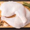 Raw turkey thighs on a cutting board with garlic cloves, spices and a rosemary sprig