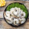 Raw shrimp in a black bowl with lemon